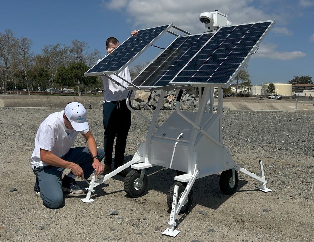 Allvuz personnel setting up a Mobile Surveillance System (MSS) with solar panels and high-definition cameras, designed for versatile and remote monitoring in rugged outdoor environments.